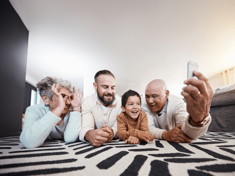 Grandparents on floor taking selfie with grandchild