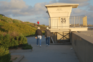 Older couple walking down beach boardwalk