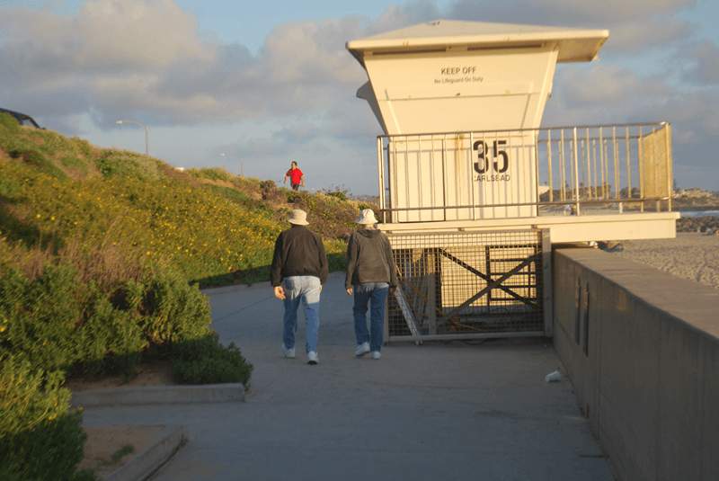 Older couple walking down beach boardwalk